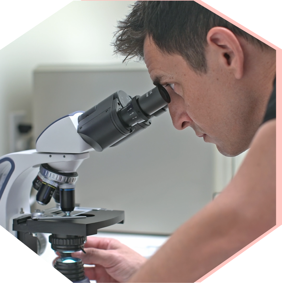 Urologist examining a sample through a microscope